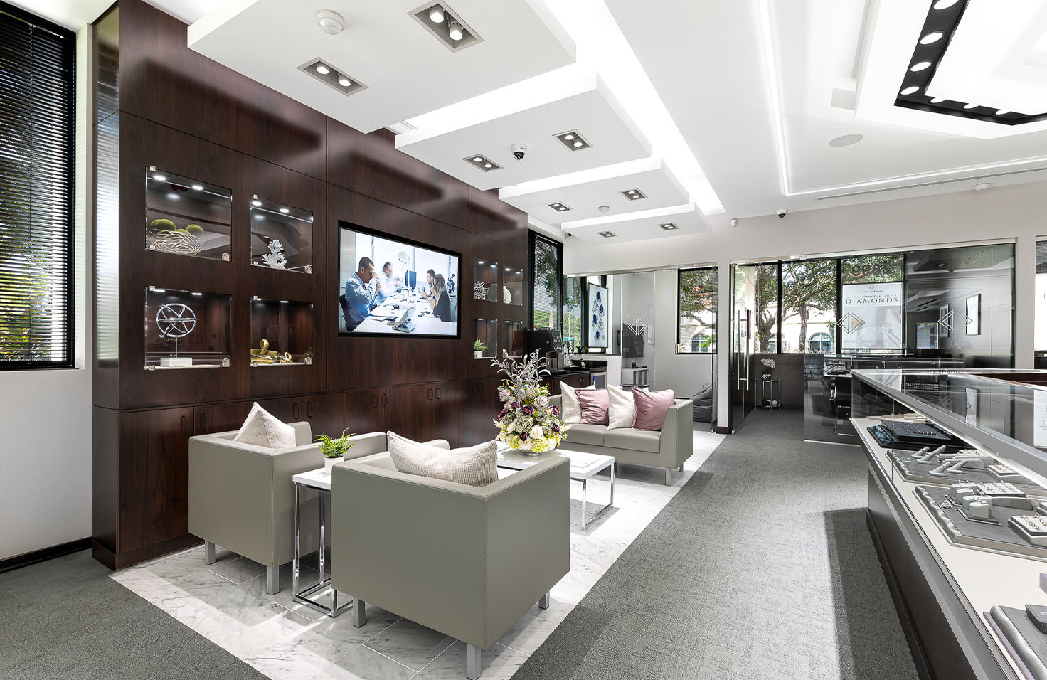 Diamonds Direct showroom lounge area with glass showcases featuring fine jewelry collections.