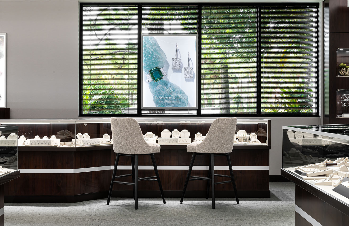 Diamonds Direct showroom interior featuring diamond showcases with elegant seating.