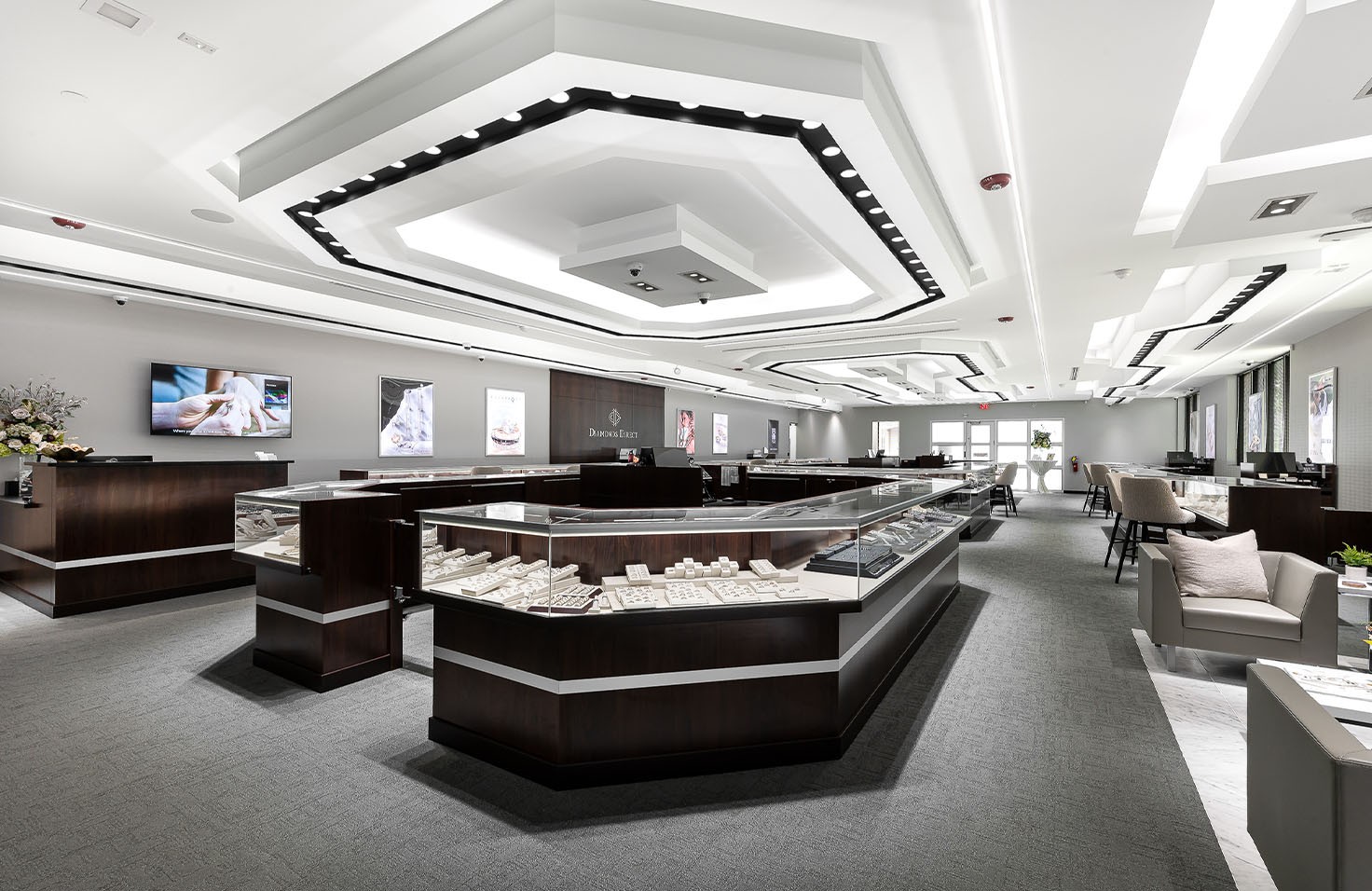 Diamonds Direct showroom with illuminated glass display cases featuring engagement rings.