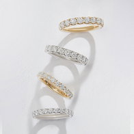 White gold and yellow gold bands with diamonds arranged on a white surface.