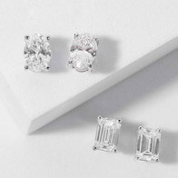 {"en-us":"Diamond stud earrings in round and emerald‑cut settings displayed on a white surface."}