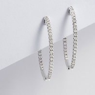 White gold diamond hoop earrings displayed on a white surface.