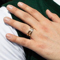 Gold band ring with baguette‑cut diamonds worn on hand.